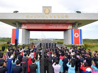 Attendees applaud as North Korea and Russia open their first road bridge, a structure that spans the Tumen river connecting the border cities of Rason and Khasan,  in this picture released by North Korea's official Korean Central News Agency, Septemb