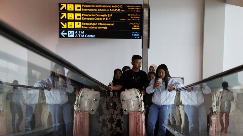 Penumpang berdiri di eskalator saat Bandara Internasional Soekarno-Hatta dibuka kembali pasca letusan Gunung Anak Krakatau, di Tangerang, dekat Jakarta, Indonesia, 8 September 2026.