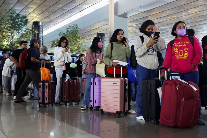 Penumpang berjalan di terminal saat Bandara Internasional Soekarno-Hatta dibuka kembali pasca letusan Gunung Anak Krakatau, di Tangerang, dekat Jakarta, Indonesia, 8 September 2026. (REUTERS/Ajeng Dinar Ulfiana)