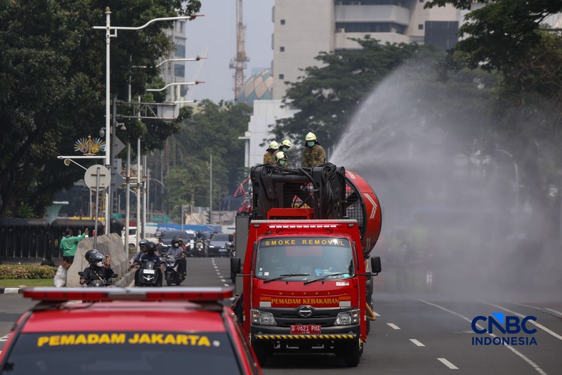 Petugas melakukan penyemprotan air dalam bentuk kabut halus bertekanan tinggi atau water mist di Jakarta, Selasa (8/9/2026).  (CNBC Indonesia/Faisal Rahman)