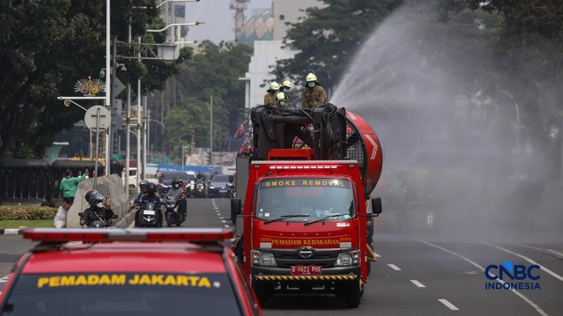 Petugas melakukan penyemprotan air dalam bentuk kabut halus bertekanan tinggi atau water mist di Jakarta, Selasa (8/9/2026).  (CNBC Indonesia/Faisal Rahman)
