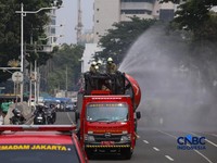 Petugas melakukan penyemprotan air dalam bentuk kabut halus bertekanan tinggi atau water mist di Jakarta, Selasa (8/9/2026).  (CNBC Indonesia/Faisal Rahman)