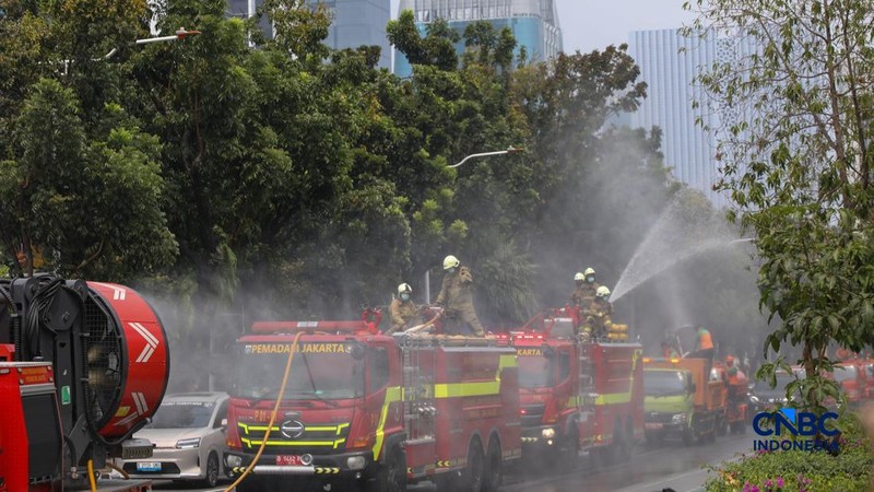 Petugas melakukan penyemprotan air dalam bentuk kabut halus bertekanan tinggi atau water mist di Jakarta, Selasa (8/9/2026).  (CNBC Indonesia/Faisal Rahman)