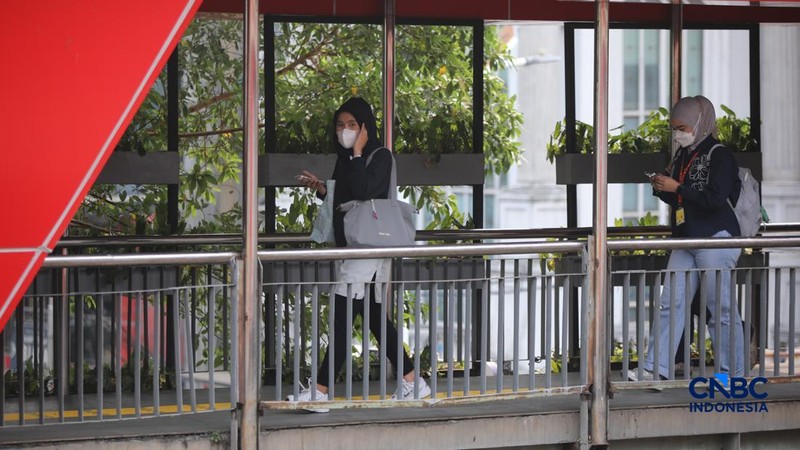 Sejumlah pekerja swasta mengenakan masker saat beraktivitas di luar ruangan di trotoar kawasan Jalan Sudirman, Jakarta, Selasa (8/9/2026).