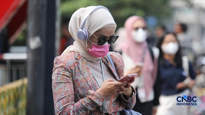 Sejumlah pekerja swasta mengenakan masker saat beraktivitas di luar ruangan di trotoar kawasan Jalan Sudirman, Jakarta, Selasa (8/9/2026).