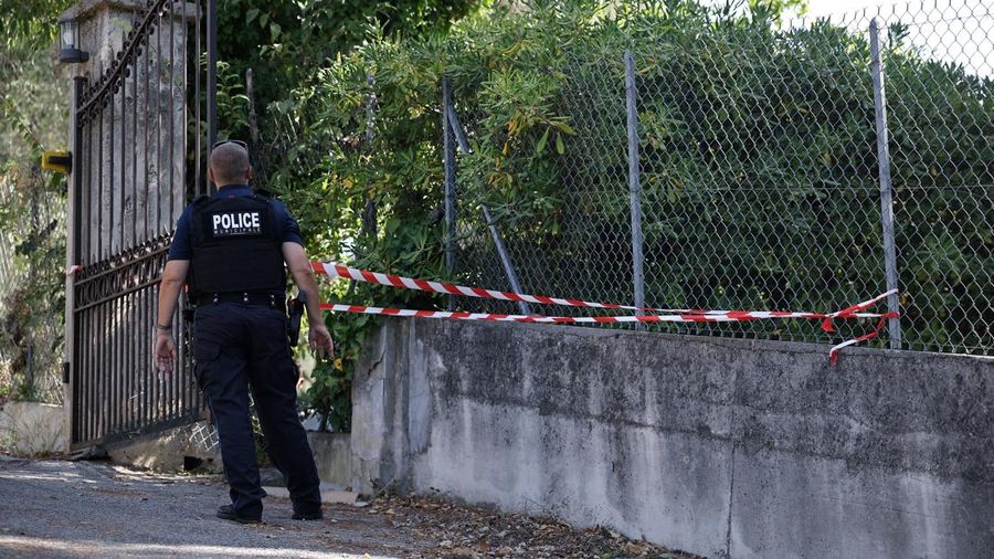 Seorang polisi setempat mengamati petugas forensik kepolisian yang sedang bekerja di dekat lubang pada pagar luar Museum Renoir setelah empat lukisan dicuri dalam aksi pembobolan pada dini hari—dengan dua di antaranya berhasil ditemukan kembali di sekitar lokasi—di Cagnes-sur-Mer, kawasan French Riviera, Prancis, pada 8 September 2026.