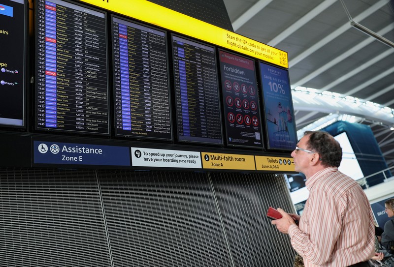 Stranded passengers use their phones after some departing flights were cancelled, at Heathrow Airport's Terminal 5 in London, Britain, September 8, 2026. Some departing flights at major British airports were disrupted on Tuesday after air traffic control provider NATS experienced a technical issue, with Heathrow, Gatwick, Manchester and Stansted among the airports affected by restrictions and delays. REUTERS/Isabel Infantes