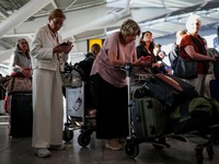 Stranded passengers use their phones after some departing flights were cancelled, at Heathrow Airport's Terminal 5 in London, Britain, September 8, 2026. Some departing flights at major British airports were disrupted on Tuesday after air traffic con