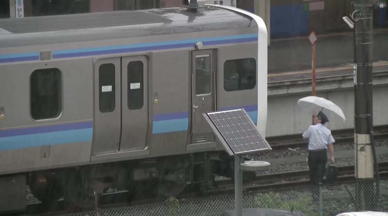 Sebuah mobil melaju di jalan yang tergenang akibat hujan deras, sementara spanduk Asian Games Aichi-Nagoya terlihat di latar belakang di Nagoya, Jepang tengah, pada 8 September 2026, dalam foto yang diambil oleh Kyodo ini. (Mandatory credit Kyodo/via REUTERS)