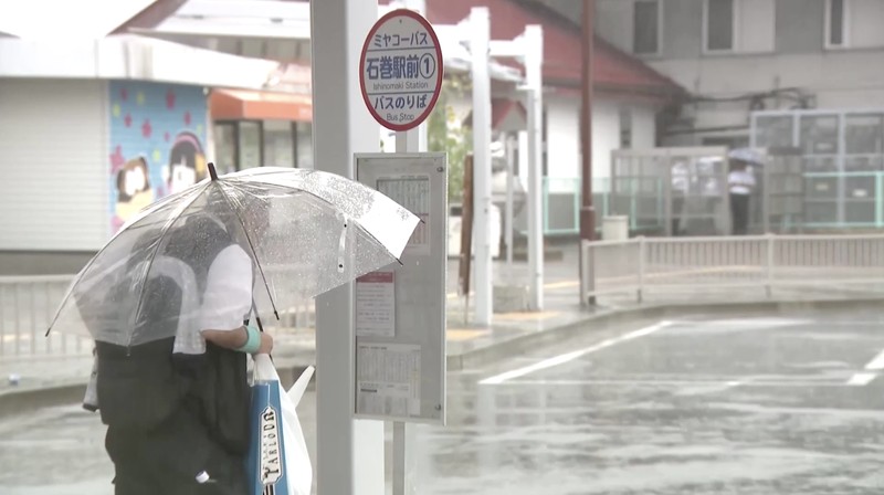 Sebuah mobil melaju di jalan yang tergenang akibat hujan deras, sementara spanduk Asian Games Aichi-Nagoya terlihat di latar belakang di Nagoya, Jepang tengah, pada 8 September 2026, dalam foto yang diambil oleh Kyodo ini. (Mandatory credit Kyodo/via REUTERS)