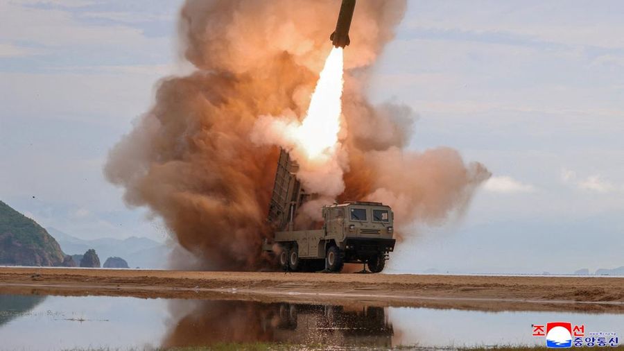 FILE PHOTO: A rocket launcher fires a munition during tests, involving an upgraded version of a 240-mm, 24-tube multiple rocket launcher system, tactical ballistic missiles, and a 155-mm self-propelled howitzer, overseen by North Korean leader Kim Jo