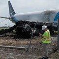 Para penyelidik dari National Transportation Safety Board (NTSB) memeriksa lokasi tempat pesawat kargo Amazon Prime Air melampaui batas landasan pacu di Bandara Internasional Miami, Florida, AS, dalam tangkapan layar yang diambil dari video rilis pad