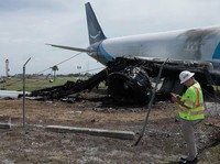 Para penyelidik dari National Transportation Safety Board (NTSB) memeriksa lokasi tempat pesawat kargo Amazon Prime Air melampaui batas landasan pacu di Bandara Internasional Miami, Florida, AS, dalam tangkapan layar yang diambil dari video rilis pad