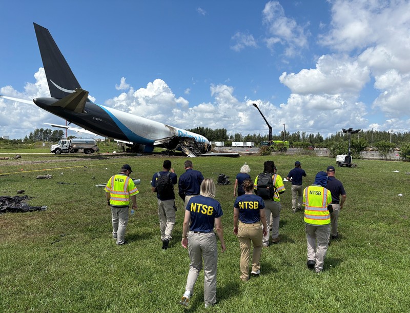 Para penyelidik National Transportation Safety Board (NTSB) memeriksa lokasi tempat pesawat kargo Amazon Prime Air melampaui batas landasan pacu di Bandara Internasional Miami, di Miami, Florida, AS, pada 7 September 2026. (National Transportation Safety Board/Handout via REUTERS)