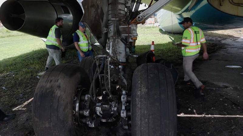 Para penyelidik National Transportation Safety Board (NTSB) memeriksa lokasi tempat pesawat kargo Amazon Prime Air melampaui batas landasan pacu di Bandara Internasional Miami, di Miami, Florida, AS, pada 7 September 2026. (National Transportation Safety Board/Handout via REUTERS)