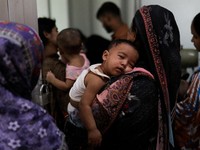 Seorang wanita menggendong anak yang menderita campak untuk mendapatkan perawatan di sebuah rumah sakit di Dhaka, Bangladesh, pada 7 September 2026. (REUTERS/Stringer)
