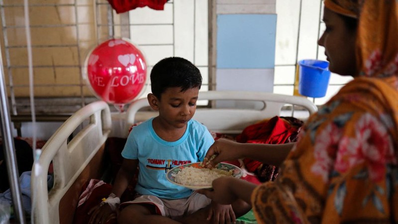 Seorang wanita menyuapi anak laki-laki yang terinfeksi demam berdarah saat ia menjalani perawatan di sebuah rumah sakit di Dhaka, Bangladesh, pada 7 September 2026.