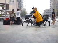 Warga melintasi jalan yang terendam banjir akibat hujan deras di Nagoya, Jepang tengah, pada 8 September 2026, dalam foto yang diambil oleh Kyodo ini. (Mandatory credit Kyodo/via REUTERS)