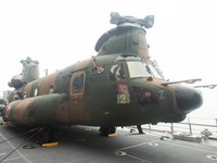 A Japanese military member stands near a Chinook helicopter on the deck of the Japanese JS Kunisaki ship, which will be used to support Indonesias efforts to fight forest fires on Kalimantan Island, in Kijing International Port, Mempawah, West Kalima