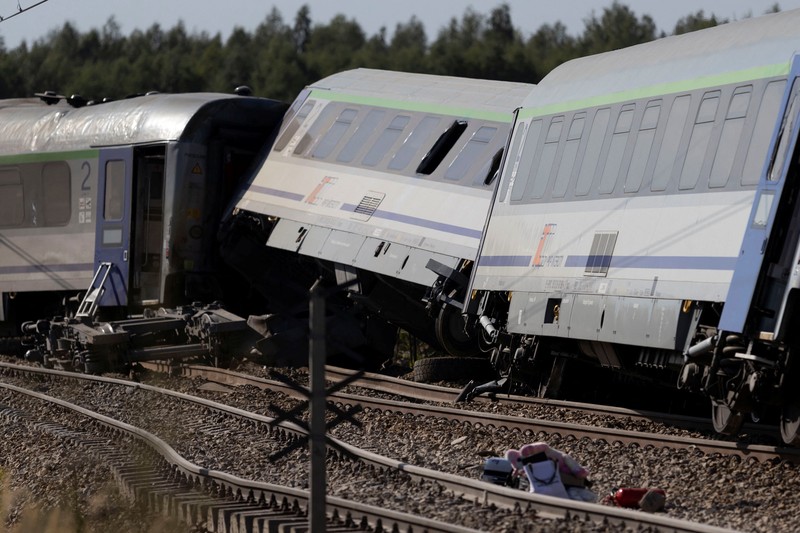 Petugas memeriksa bangkai kereta PKP Intercity Koziolek yang bertabrakan dengan sebuah truk di perlintasan kereta api dan tergelincir di Sokolniki Suche, Polandia, pada 9 September 2026. (Marcin Kucewicz/Agencja Wyborcza.pl via REUTERS)