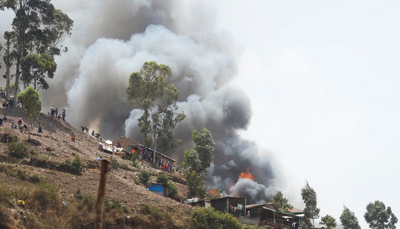 Congolese civilians gather as they attempt to extinguish fire at a school and neighbouring settlement in the area controlled by Rwanda-backed AFC/M23 rebels since the group staged an offensive in eastern Congo in February 2025, in Bukavu, Democratic Republic of Congo, September 10, 2026. REUTERS/Victoire Mukenge