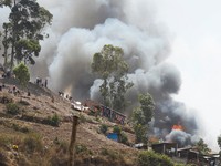 Congolese civilians gather as they attempt to extinguish fire at a school and neighbouring settlement in the area controlled by Rwanda-backed AFC/M23 rebels since the group staged an offensive in eastern Congo in February 2025, in Bukavu, Democratic