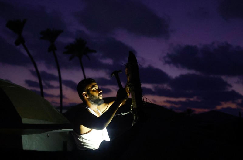 A Palestinian man lights a fire inside a tent amid shortages of electricity and fuel, in Khan Younis, in the southern Gaza Strip, September 5, 2026. REUTERS/Ramadan Abed
