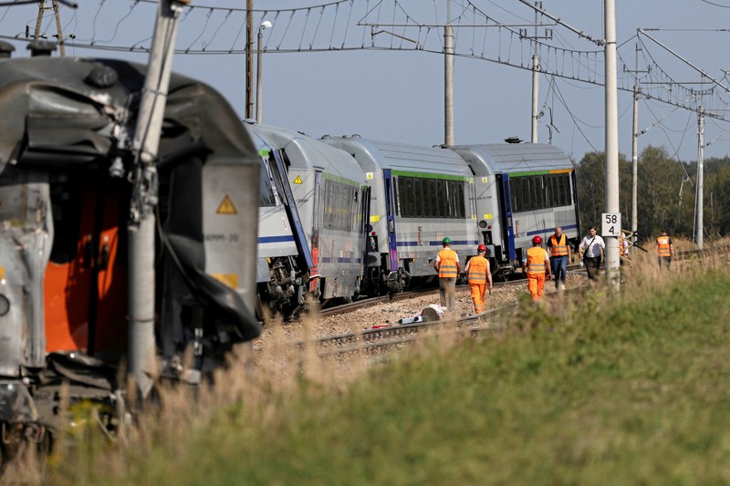 Petugas memeriksa bangkai kereta PKP Intercity Koziolek yang bertabrakan dengan sebuah truk di perlintasan kereta api dan tergelincir di Sokolniki Suche, Polandia, pada 9 September 2026. (Marcin Kucewicz/Agencja Wyborcza.pl via REUTERS)