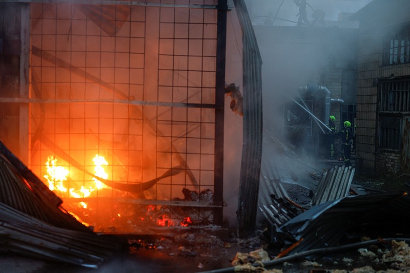 Kebakaran besar melanda sebuah gudang di Kyiv, Ukraina, setelah serangan rudal menghantam ibu kota di tengah krisis pertahanan udara, Minggu (13/9/2026). (REUTERS/Valentyn Ogirenko)