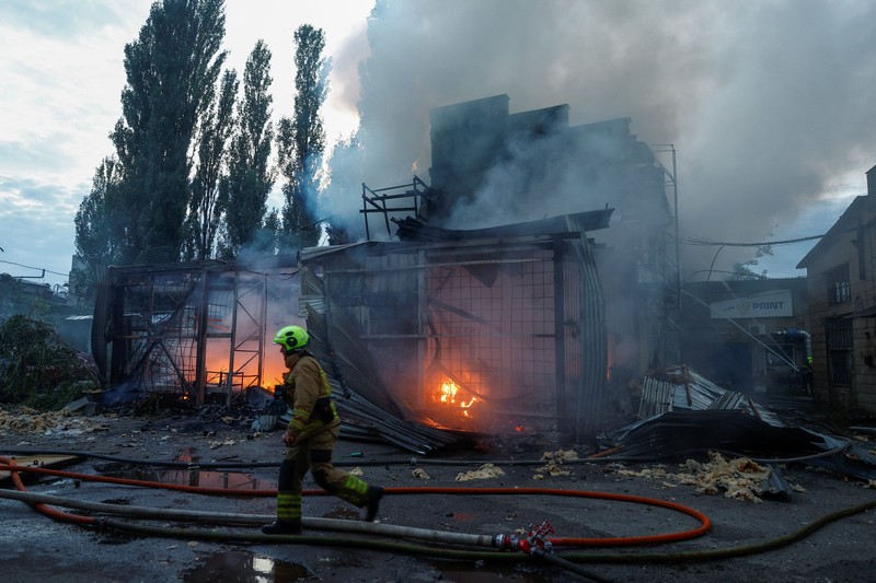 Kebakaran besar melanda sebuah gudang di Kyiv, Ukraina, setelah serangan rudal menghantam ibu kota di tengah krisis pertahanan udara, Minggu (13/9/2026). (REUTERS/Valentyn Ogirenko)