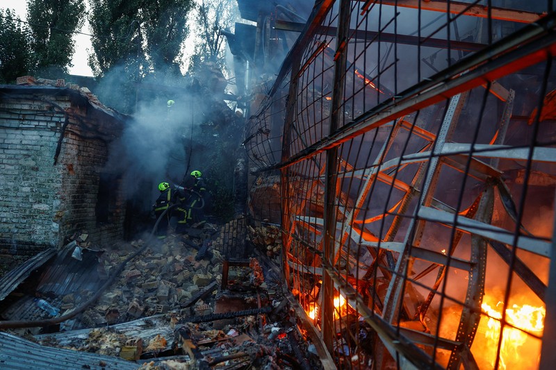 Kebakaran besar melanda sebuah gudang di Kyiv, Ukraina, setelah serangan rudal menghantam ibu kota di tengah krisis pertahanan udara, Minggu (13/9/2026). (REUTERS/Valentyn Ogirenko)