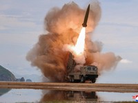 FILE PHOTO: A rocket launcher fires a munition during tests, involving an upgraded version of a 240-mm, 24-tube multiple rocket launcher system, tactical ballistic missiles, and a 155-mm self-propelled howitzer, overseen by North Korean leader Kim Jo