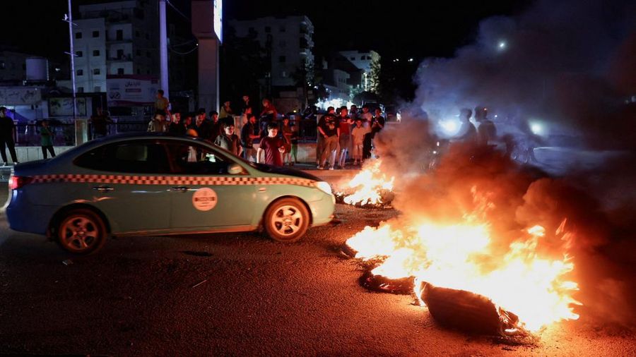 Sebuah mobil melintas di dekat ban-ban yang dibakar oleh para pengunjuk rasa yang memprotes kenaikan harga bahan bakar di Suriah, di jalan raya antara Aleppo dan Turki, Suriah, 13 September 2026.