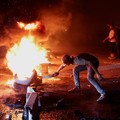 Seorang pengunjuk rasa di Aleppo membakar ban untuk memprotes kenaikan harga bahan bakar di Suriah, di jalan raya antara Aleppo dan Turki, Suriah, 13 September 2026. (REUTERS/Mahmoud Hassano)