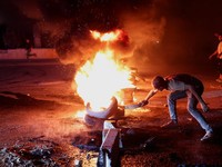 Seorang pengunjuk rasa di Aleppo membakar ban untuk memprotes kenaikan harga bahan bakar di Suriah, di jalan raya antara Aleppo dan Turki, Suriah, 13 September 2026. (REUTERS/Mahmoud Hassano)
