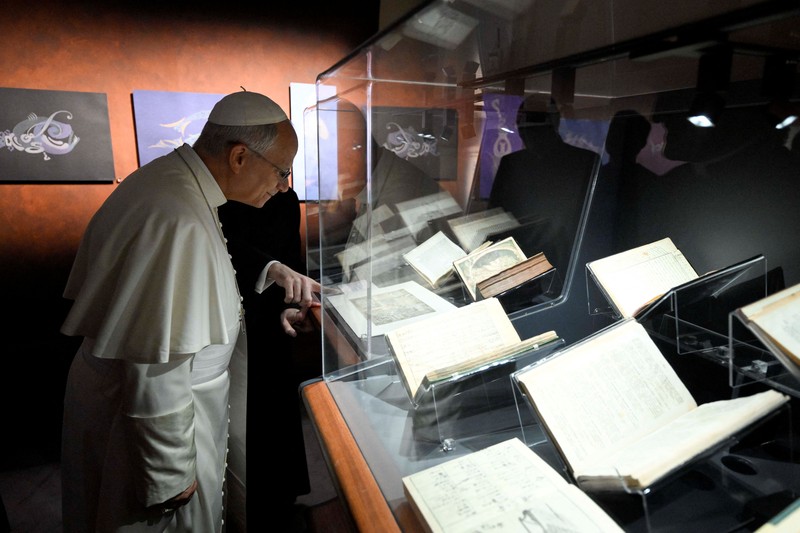 Paus Leo melambaikan tangan saat tiba di Perpustakaan Apostolik Vatikan untuk peresmian pameran