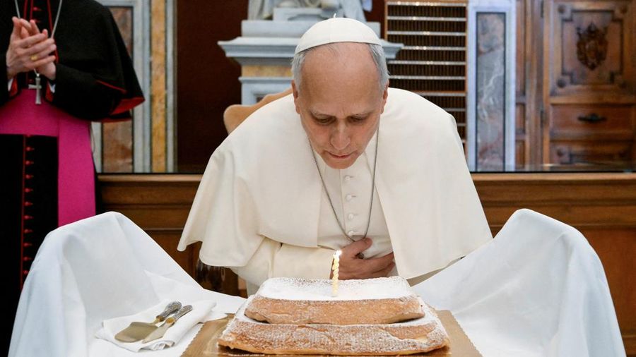 Paus Leo meniup lilin saat menerima kue *angel cake* dari para pegawai Vatikan untuk merayakan ulang tahunnya yang ke-71, dalam kunjungannya untuk meresmikan pameran