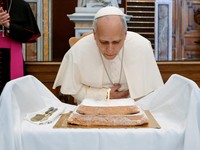 Paus Leo meniup lilin saat menerima kue *angel cake* dari para pegawai Vatikan untuk merayakan ulang tahunnya yang ke-71, dalam kunjungannya untuk meresmikan pameran "AQVA - Catastrophe and Wonder" di Perpustakaan Apostolik Vatikan, Vatikan, 14 Septe