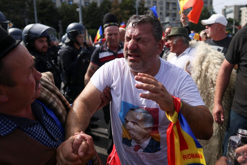 Para penggembala domba asal Rumania dan pendukung mantan calon presiden Calin Georgescu bentrok dengan petugas gendarmeri dalam sebuah unjuk rasa di depan kantor pusat pemerintah Rumania di Bukares, Rumania, pada 15 September 2026. (Inquam Photos/George Calin via REUTERS)