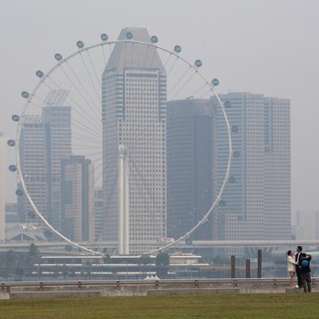 Singapore Flyer dan gedung-gedung komersial diselimuti kabut asap di kawasan Marina Bay, Singapura, pada 15 September 2026. (REUTERS/Ore Huiying)