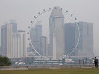 Singapore Flyer dan gedung-gedung komersial diselimuti kabut asap di kawasan Marina Bay, Singapura, pada 15 September 2026. (REUTERS/Ore Huiying)