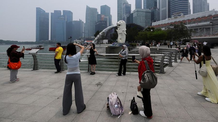 Wisatawan berfoto dengan latar belakang Merlion saat cakrawala kota diselimuti kabut asap akibat kebakaran hutan di wilayah sekitar yang mengurangi jarak pandang di seluruh negara kota kepulauan tersebut, di Singapura, 14 September 2026. Wisatawan berfoto dengan latar belakang Merlion saat cakrawala kota diselimuti kabut asap akibat kebakaran hutan di wilayah sekitar yang mengurangi jarak pandang di seluruh negara kota kepulauan tersebut, di Singapura, 14 September 2026.