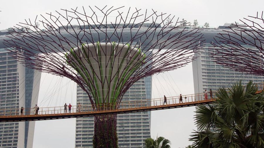 Wisatawan berjalan di jembatan OCBC Skyway di Gardens by the Bay saat Hotel Marina Bay Sands diselimuti kabut asap di Singapura, 15 September 2026.