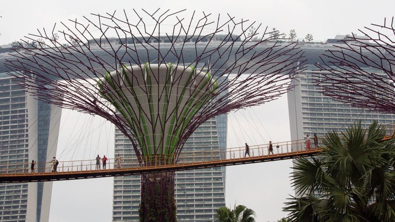 Wisatawan berjalan di jembatan OCBC Skyway di Gardens by the Bay saat Hotel Marina Bay Sands diselimuti kabut asap di Singapura, 15 September 2026.