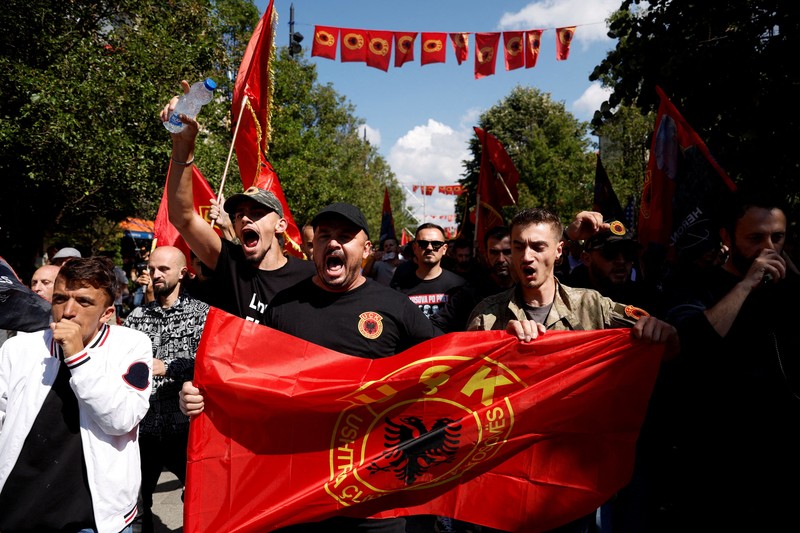 Seseorang memegang suar asap saat para pendukung mantan Presiden Kosovo Hashim Thaci berkumpul di Pristina, Kosovo, pada 16 September 2026&mdash;hari ketika Thaci dan mantan anggota Tentara Pembebasan Kosovo (KLA) lainnya mendengarkan putusan dalam sidang pengadilan kejahatan perang mereka di Kosovo Specialist Chambers di Den Haag. (REUTERS/Florion Goga)