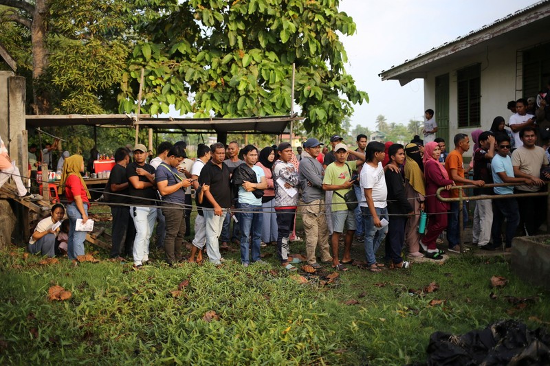 Pendukung sebuah kelompok politik bersorak setelah menghancurkan sebuah kendaraan selama pemilihan parlemen pertama Daerah Otonom Bangsamoro di Mindanao Muslim (BARMM), di luar Sekolah Dasar Sero Central, Kota Cotabato, Filipina, Senin (14/9/2026). (REUTERS/MANMAN DEJETO)