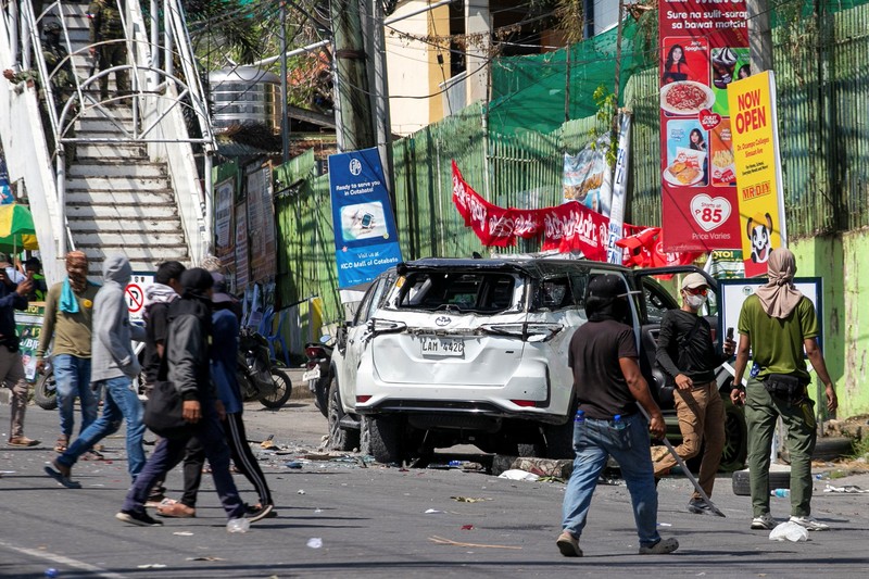 Pendukung sebuah kelompok politik bersorak setelah menghancurkan sebuah kendaraan selama pemilihan parlemen pertama Daerah Otonom Bangsamoro di Mindanao Muslim (BARMM), di luar Sekolah Dasar Sero Central, Kota Cotabato, Filipina, Senin (14/9/2026). (REUTERS/MANMAN DEJETO)