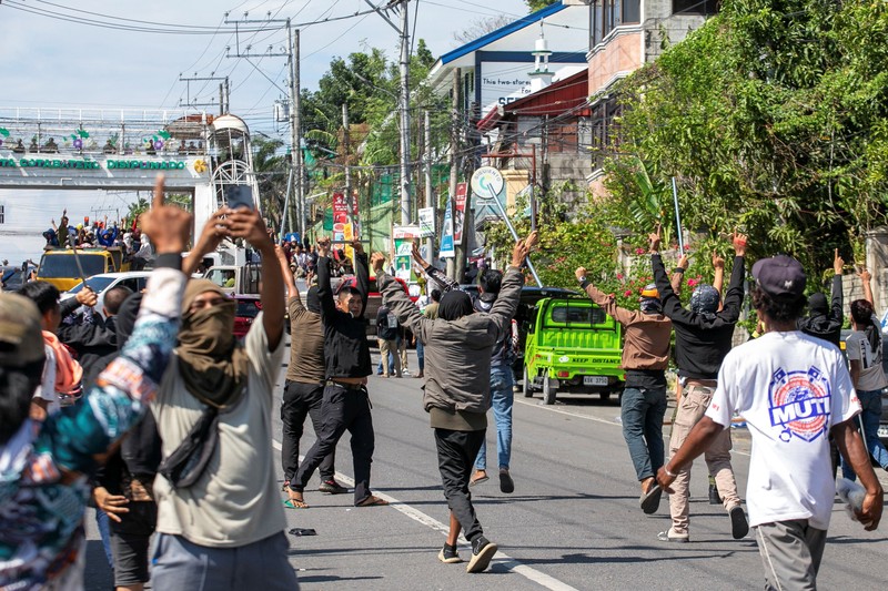 Pendukung sebuah kelompok politik bersorak setelah menghancurkan sebuah kendaraan selama pemilihan parlemen pertama Daerah Otonom Bangsamoro di Mindanao Muslim (BARMM), di luar Sekolah Dasar Sero Central, Kota Cotabato, Filipina, Senin (14/9/2026). (REUTERS/MANMAN DEJETO)