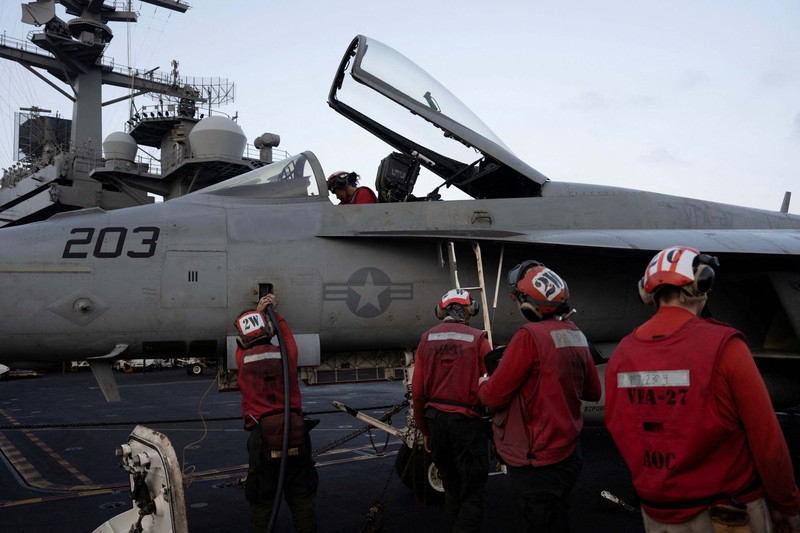 Seorang personel Angkatan Laut AS menangani amunisi di dek penerbangan USS George Washington di Laut Arab, Minggu (13/9/2026). (REUTERS/Ed Ou)