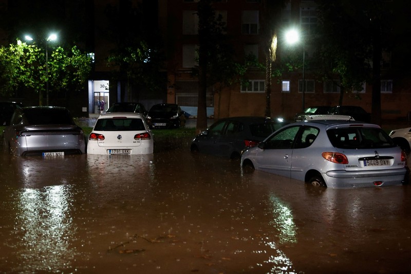 Kendaraan yang terendam sebagian tampak dikelilingi air banjir di tengah hujan, setelah otoritas setempat mengeluarkan peringatan cuaca di Valencia, Spanyol, pada 17 September 2026. (REUTERS/Eva Manez)
